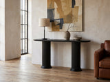 Imola Black Wood Veneer Oval Column Console Table against a plaster wall in an industrial loft