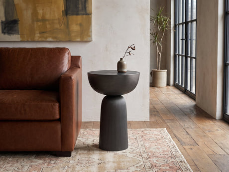 Irsina Cast Aluminum Tulip Pedestal Side Table beside a leather sofa in an industrial loft