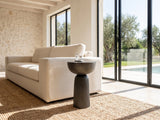 Irsina Cast Aluminum Tulip Pedestal Side Table beside a linen sofa in a poolside villa