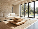 Ischia Natural Wood Veneer Stacking Coffee Table on a jute rug in front of a linen sofa in a poolside villa