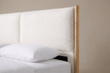One side of the Isernia headboard: a round wooden post with a domed top, a plump cream cushion with a rounded corner and the seam to the second cushion, above a white pillow