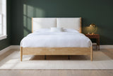 Isernia bed against a deep green wall in a Nashville farmhouse bedroom with a cream wool rug and pale oak floor
