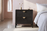 Isili black fluted nightstand against a blush pink limewash wall in a Palm Springs bedroom with a pale concrete floor and an arched window