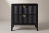 The Isili nightstand, front view on a light studio backdrop: two fluted drawers with brass half-moon pulls and four square tapered legs