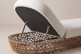 The head end of the Isnello lounger from behind: the raised backrest with its dark underside on two metal supports inside the woven base