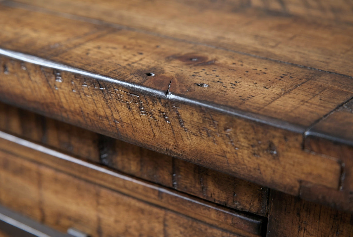 Close-up of the rough-sawn reclaimed pine at the corner of the framed top of the Ittiri nightstand, with a knot, nail holes and a dark rubbed edge