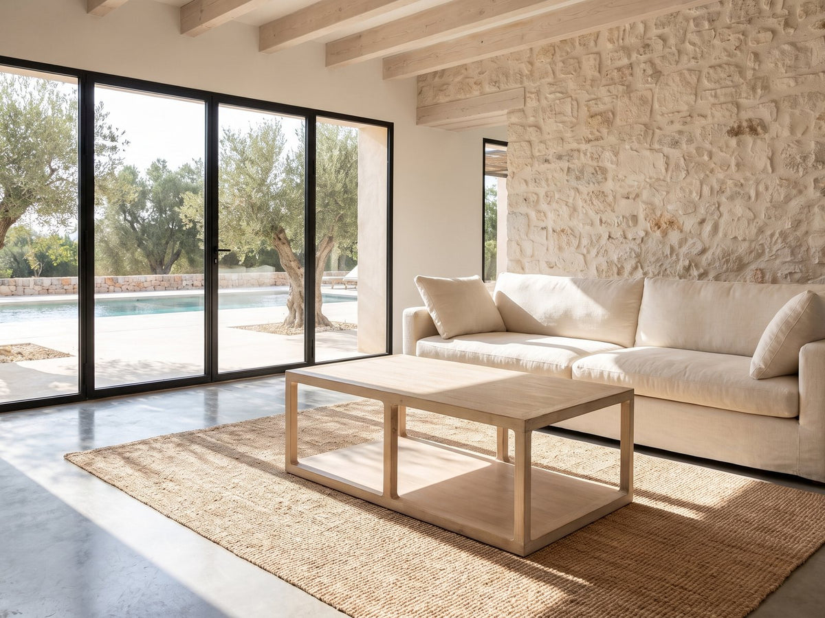 Ivrea Reclaimed Pine Open-Frame Coffee Table on a jute rug in front of a linen sofa in a poolside villa