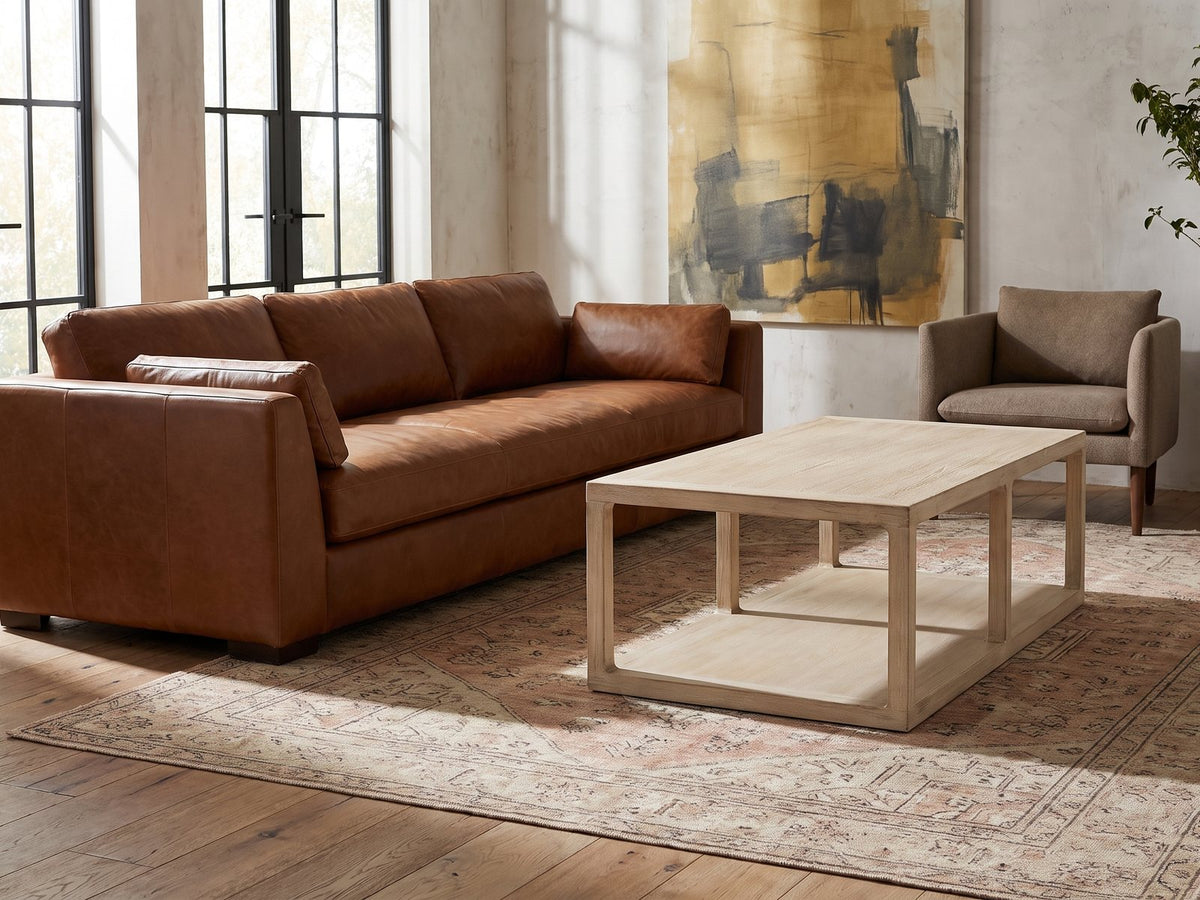 Ivrea Reclaimed Pine Open-Frame Coffee Table on a vintage rug in front of a leather sofa in an industrial loft