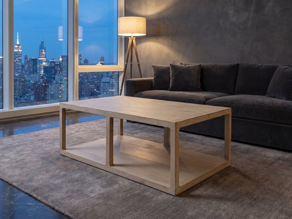 Ivrea Reclaimed Pine Open-Frame Coffee Table on a wool rug in front of a velvet sofa in a city penthouse at blue hour