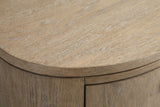 Close-up of the Jerzu nightstand: wire-brushed toffee wood veneer with pale-filled pores along the edge of the oval top and the curved side below it