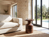 Lagonegro Solid Mango Pedestal Side Table beside a linen sofa in a poolside villa