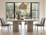 Laino 82-Inch Racetrack Oak Double Pedestal Dining Set with 4 Chairs in a sunlit villa dining area with olive trees outside