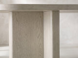 Close-up of the Laino 82-Inch Racetrack Oak Double Pedestal Dining Set with 4 Chairs: a T-shaped slab pedestal in grey-washed oak under the edge of the top