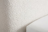 Close-up of the Lanciano pearl white chenille upholstery, a dense nubby curly weave, beside the edge of a white mattress cover
