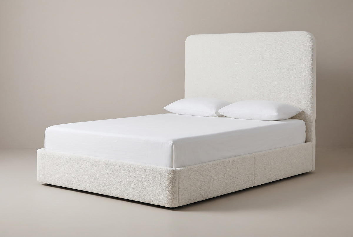 The Lanciano bed in pearl white chenille with a white mattress and pillows (not included), three-quarter view on a light studio backdrop