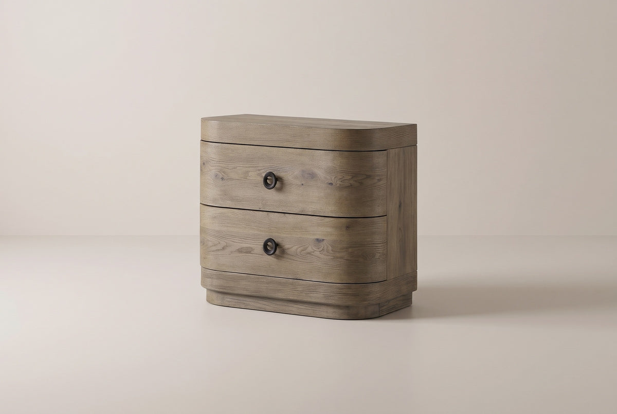 The Lanusei two-drawer nightstand in weathered knotty oak with black ring knobs and rounded front corners, three-quarter view on a light studio backdrop
