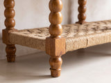 Close-up of the Laterza Mango Wood Spindle Console Table: a bobbin-turned mango leg meeting the woven cord lower shelf above a turned foot