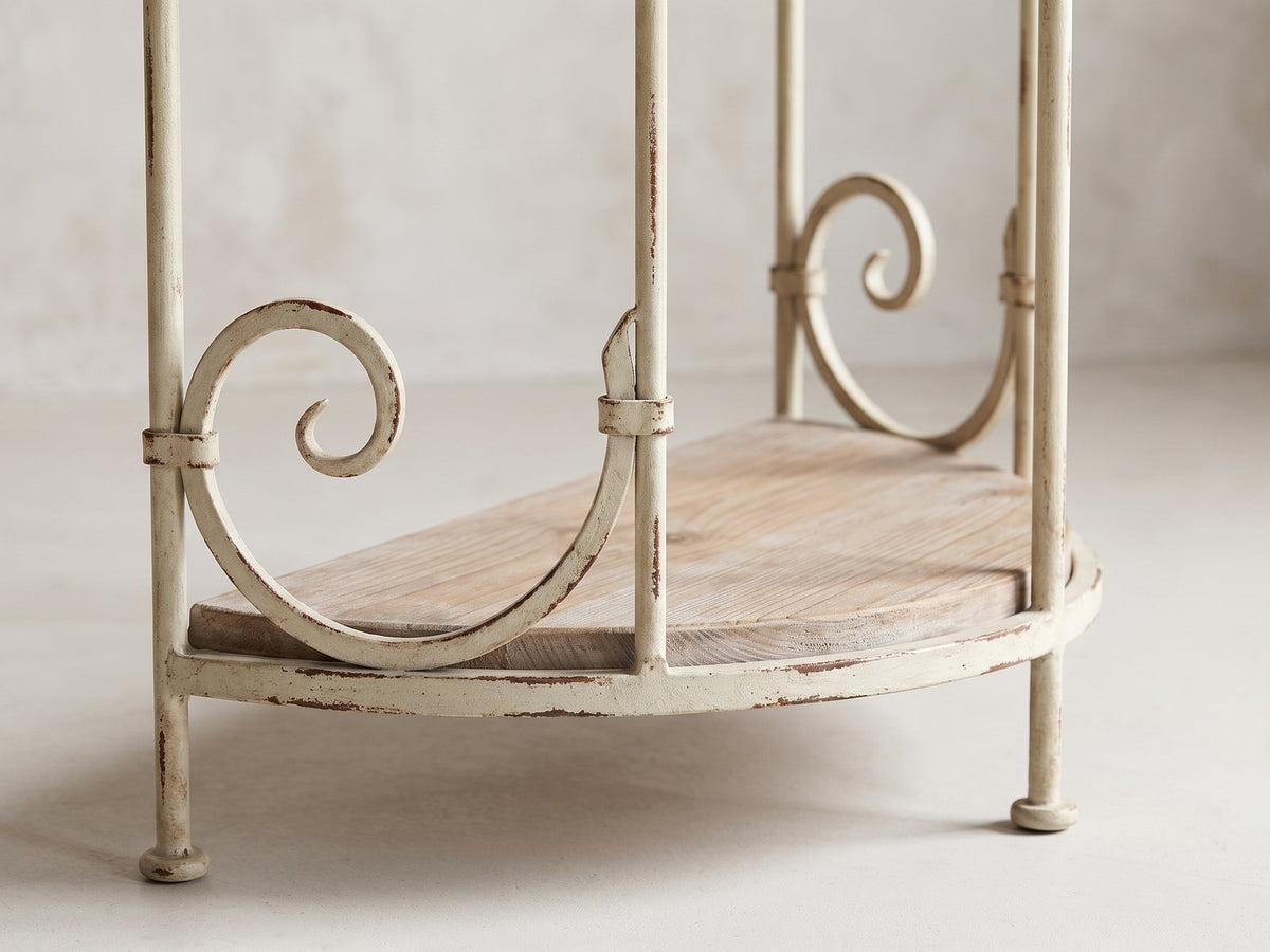 Close-up of the Latiano Fir and Scrolled Iron Three-Tier Console Table: the scrolled iron end frame above the bottom shelf