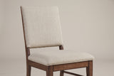 A Lavello chair close up: the square upholstered back with a thin piped edge, the open gap above the padded seat, and the wooden frame