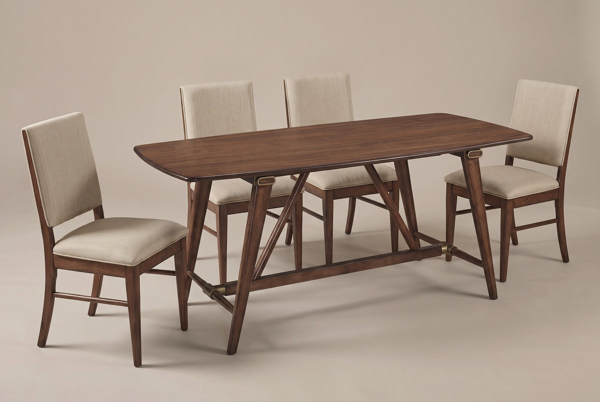 The Lavello dining set: a walnut veneer trestle table with four beige upholstered side chairs, three-quarter view on a light studio backdrop