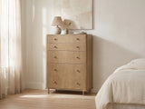 Lazise 38-Inch Sand Wash 5-Drawer Chest against a plaster wall under an abstract canvas in a bright bedroom