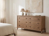 Lendinara 66-Inch Latte Elm 6-Drawer Dresser against a plaster wall under an abstract canvas in a bright bedroom