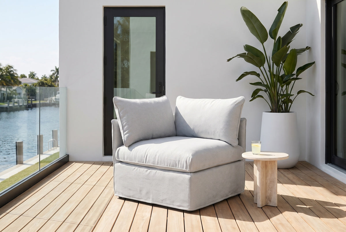 Lentini corner chair on a teak deck at a Fort Lauderdale waterfront house, a white stucco wall, a black-framed door and a bird of paradise behind (side table not included)