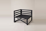 The bare black metal frame of the Lentini corner chair: railed backs on two sides, square legs, an X brace and a woven seat deck