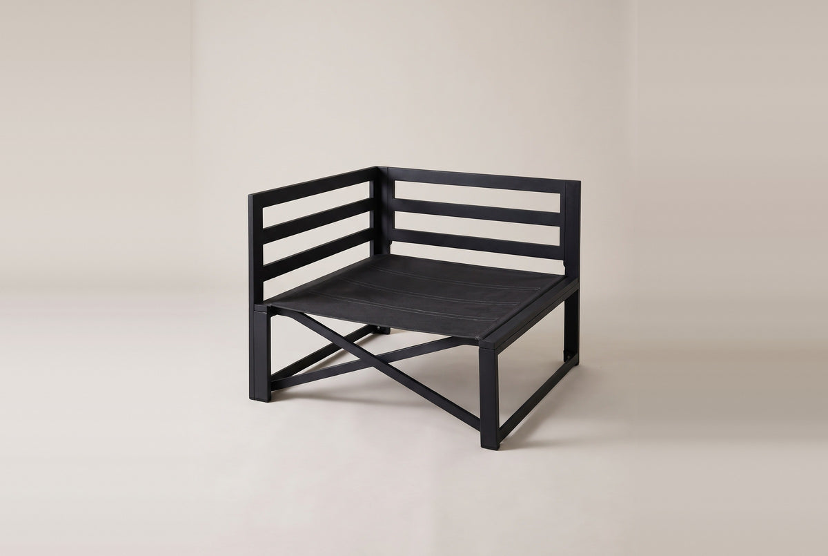 The bare black metal frame of the Lentini corner chair: railed backs on two sides, square legs, an X brace and a woven seat deck
