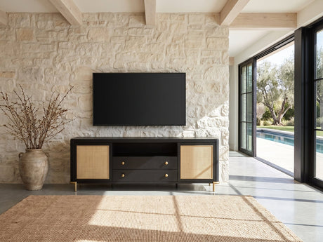 Levanto 80-Inch Black Ash and Rattan Media Console under a wall-mounted screen on a pale stone wall in a poolside villa