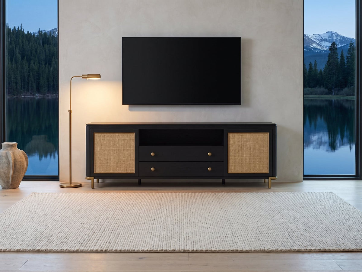 Levanto 80-Inch Black Ash and Rattan Media Console under a wall-mounted screen in a mountain lake house at dusk