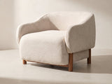 Lido Curved Shell Lounge Chair in oatmeal against a plaster wall in morning light