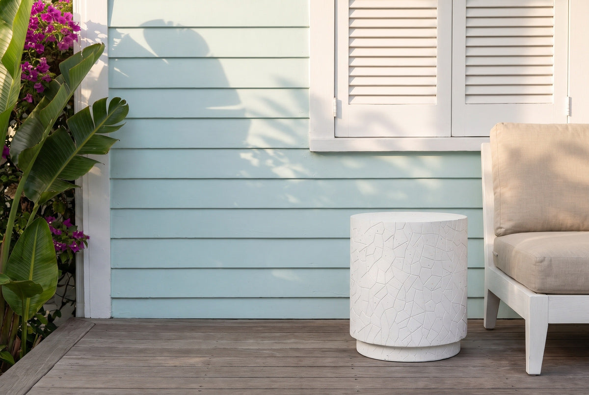 Linguaglossa white speckled concrete drum side table on a Key West cottage deck, a pale aqua clapboard wall and a white lounge chair beside it (chair not included)