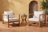 Linosa acacia lounge chairs and concrete side table in a San Antonio courtyard, an ochre lime-washed wall with an arched wooden door, saltillo tiles and a pomegranate tree (bowl of limes not included)