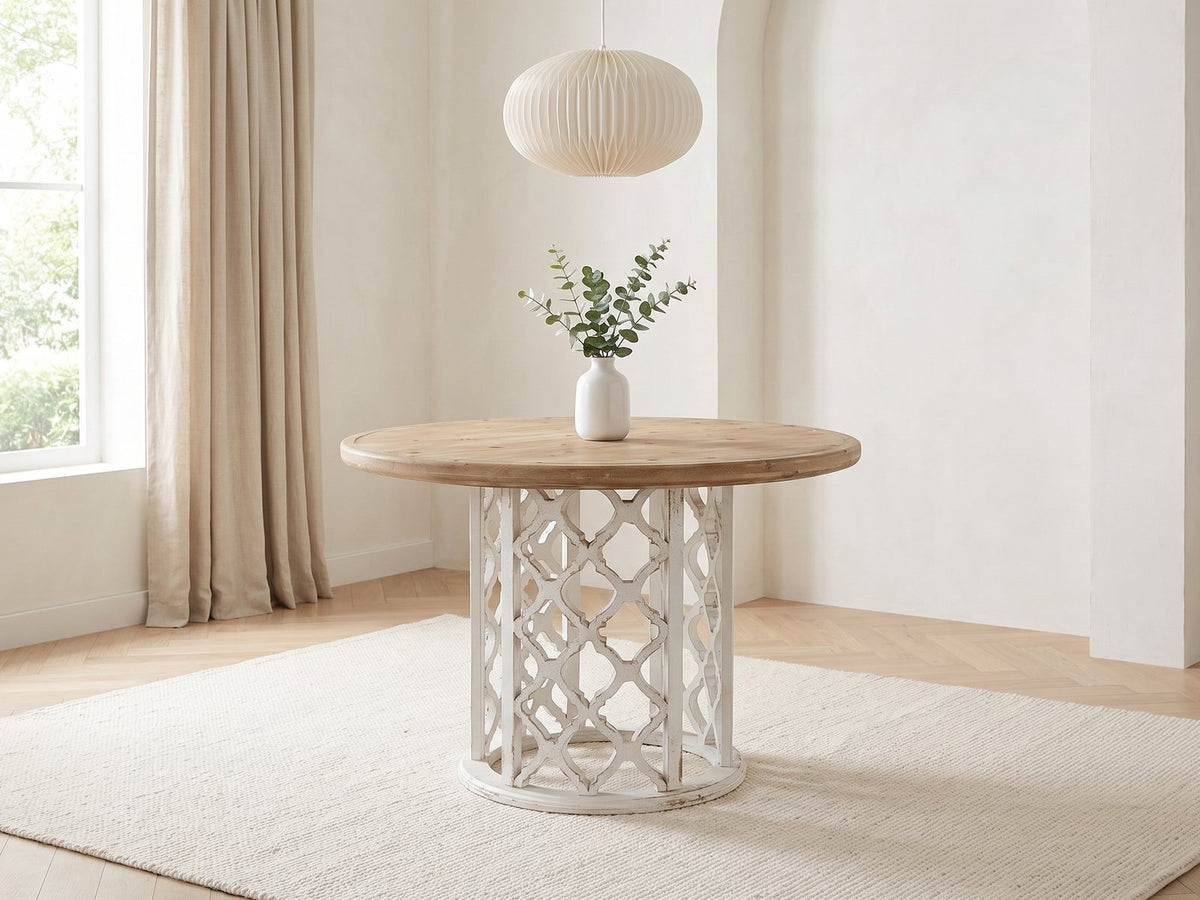 Locri 47-Inch Round Fir Lattice Pedestal Dining Table in a bright plaster dining room with linen curtains