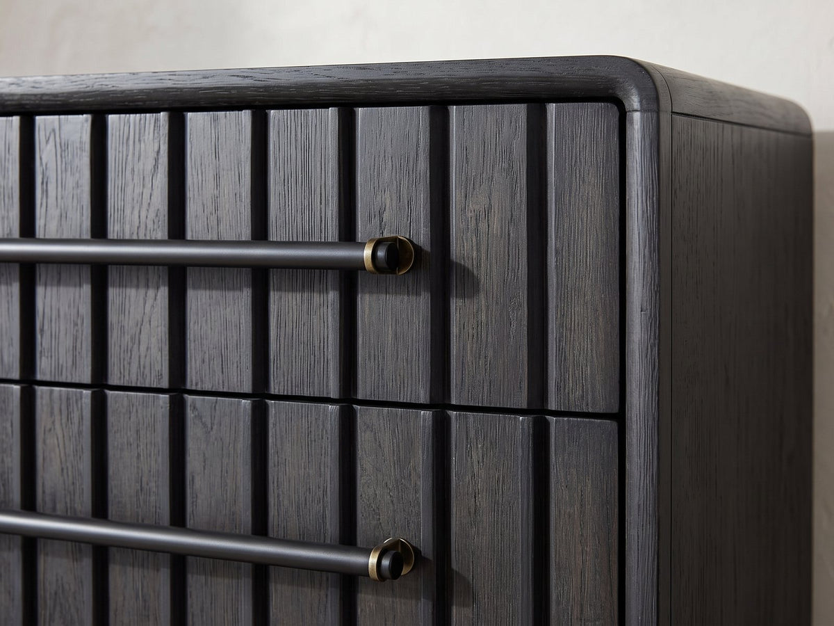 Close-up of the Lonigo 38-Inch Peppercorn 3-Drawer Chest: the black bar pull and its brass bracket over the ribbed drawer front