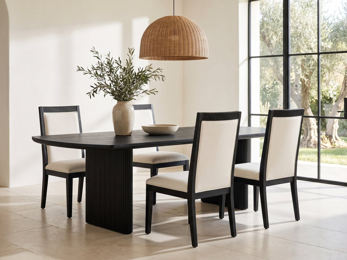 Lungro 82-Inch Reeded Black Oak Extension Dining Set with 4 Chairs in a sunlit villa dining area with olive trees outside