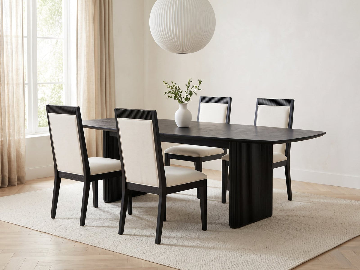 Lungro 82-Inch Reeded Black Oak Extension Dining Set with 4 Chairs in a bright plaster dining room with linen curtains
