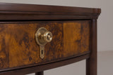 The upper drawer of the Luras nightstand: three leaves of golden poplar burl, a round brass-tone knob on a beaded rosette and a keyhole plate below it, under the dark cherry top