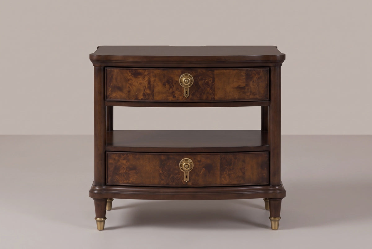 The Luras nightstand in dark cherry, front view on a warm studio backdrop: two bowed burl drawers with brass knobs, an open tier and shelf, and four brass-capped legs