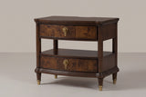 The Luras two-drawer nightstand in dark cherry with golden burl drawer fronts, brass knobs, an open tier and shelf and brass-capped legs, three-quarter view on a warm studio backdrop