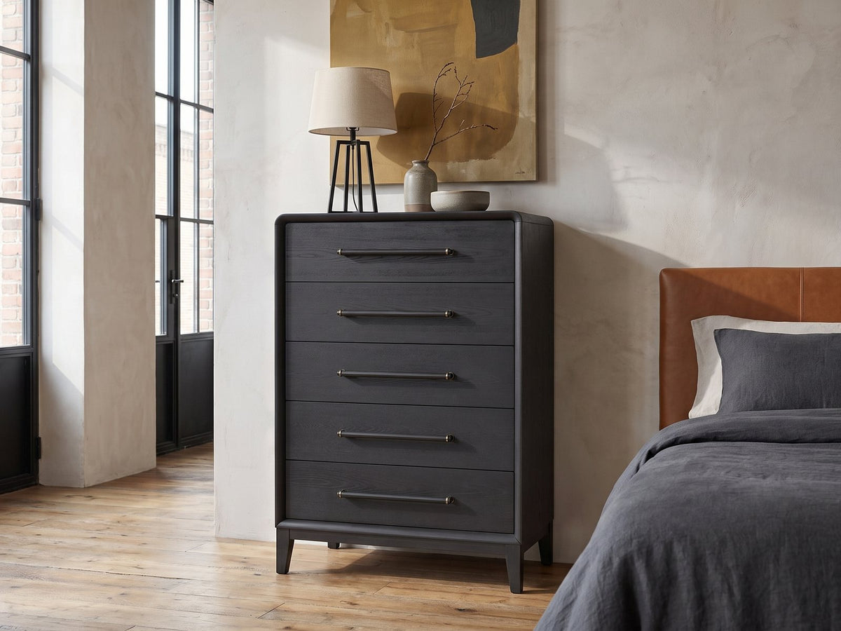 Lusiana 35-Inch Peppercorn Black 5-Drawer Chest against a plaster wall in an industrial loft bedroom