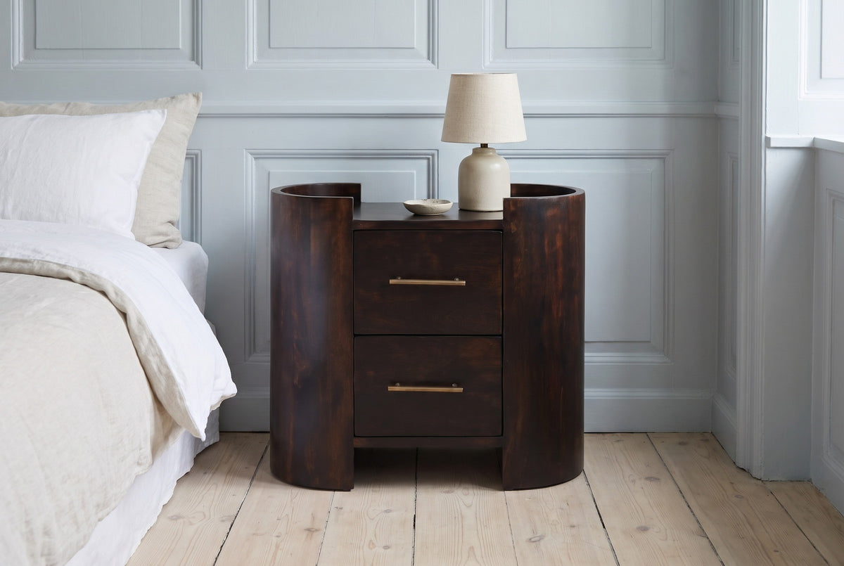 Macomer mocha mango oval nightstand with a ceramic lamp against a powder blue panelled wall in a Copenhagen bedroom with pale oak floorboards