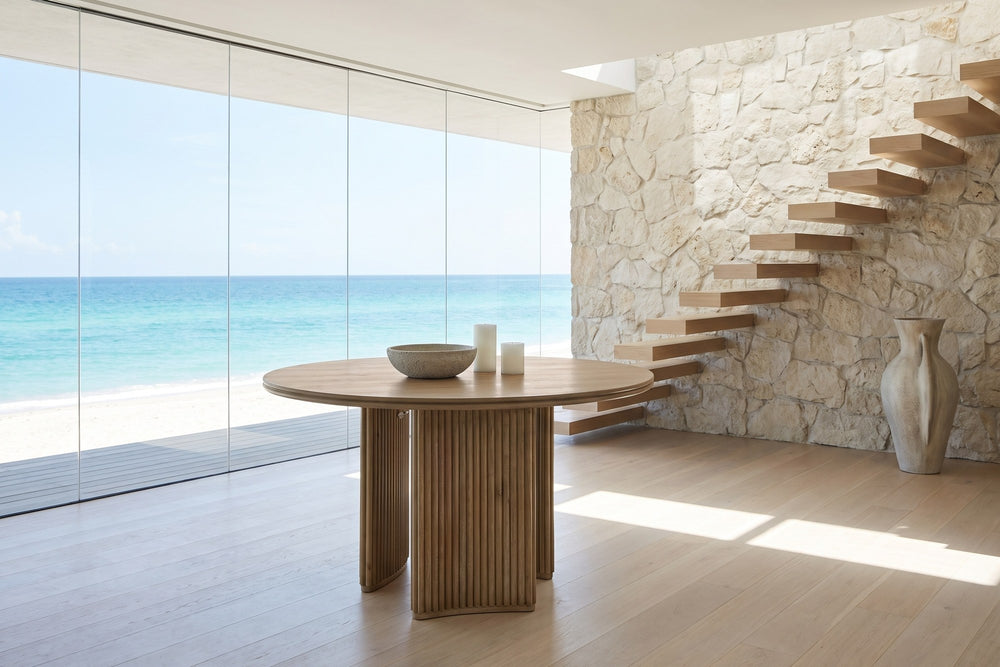 Malvito 53-Inch Round Ash Veneer Reeded Pedestal Dining Table in an oceanfront glass house