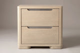 The Mandas nightstand, front view on a light studio backdrop: two plain drawers with nickel-lined scoops and two low rounded feet