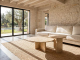 Mantova Gold Beige Marble Nesting Coffee Tables, Set of 2 on a jute rug in front of a linen sofa in a poolside villa