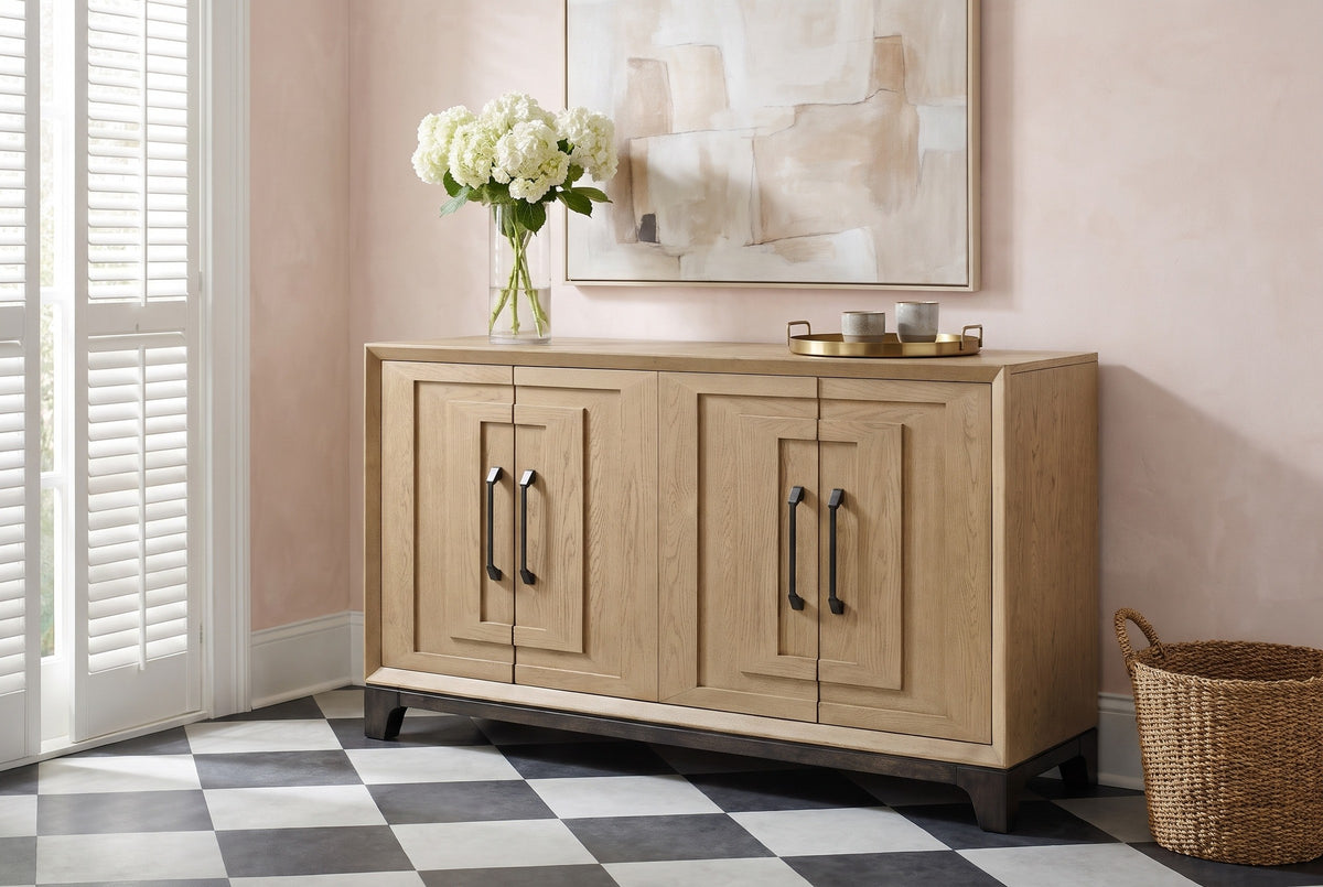 Maratea oak sideboard against a blush-pink plaster wall in a New Orleans entryway, with a black-and-white tile floor and a vase of white hydrangeas on top