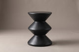 The Marineo side table from the side: a round top on a cone, a middle double cone and a cone base, zigzagging wide, narrow, wide, narrow, wide