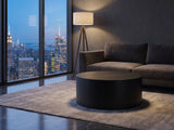 Marostica Black Mango Drum Coffee Table on a wool rug in front of a velvet sofa in a city penthouse at blue hour