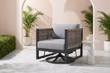The Marsala swivel glider lounge chair in a Coral Gables courtyard with a blush-pink stucco wall, arched openings, white marble pavers and potted palms (side table not included)